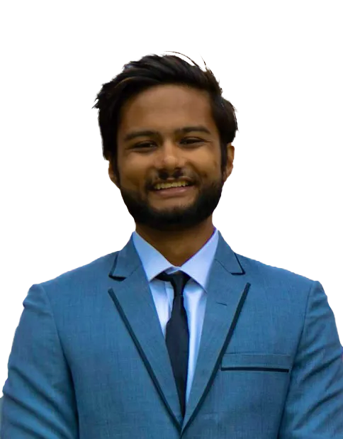 Smiling young man with dark hair and beard wearing a blue suit, white shirt, and black tie against a gray background.